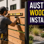 Fence installer levels horizontal cedar boards between black metal posts in a bright Austin backyard, representing a shortlist of wood-fence contractors for privacy and modern designs.
